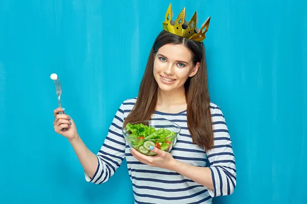 Smiling girl holding bowl with green salad. — Stock Photo, Image