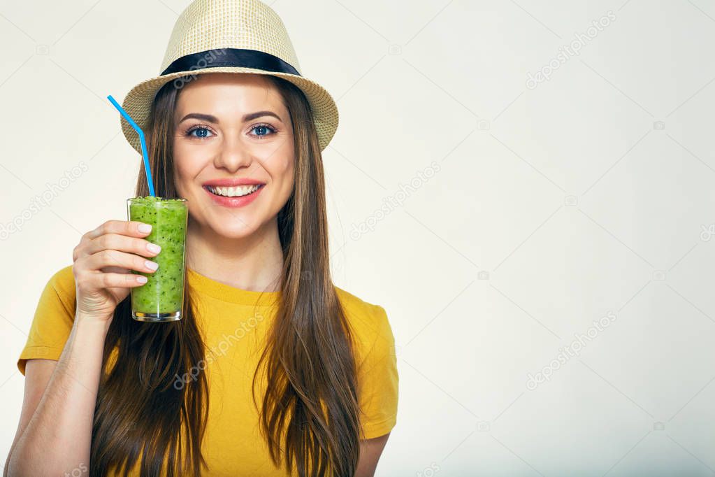 woman wearing hat holding smoothie glass.