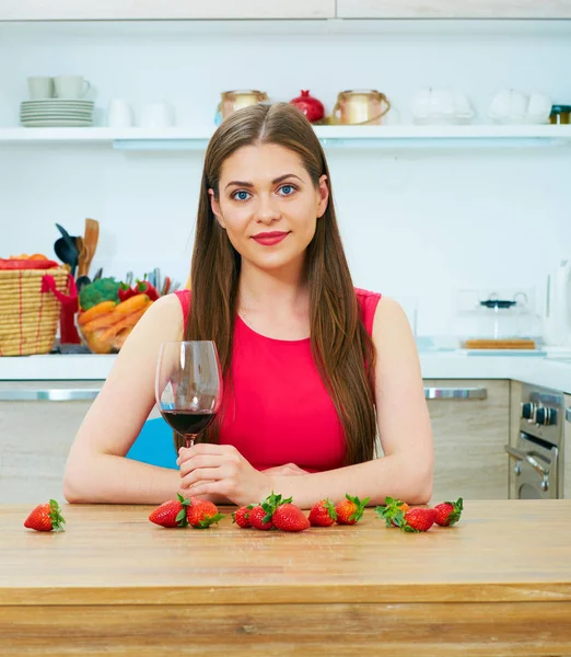 Kırmızı şarap cam mutfak çilek masada oturan tutan güzel kadın 