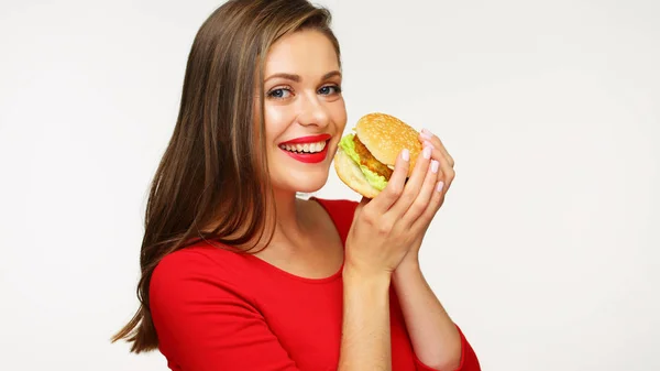 Donna sorridente che indossa un vestito rosso con in mano un grosso hamburger . — Foto Stock