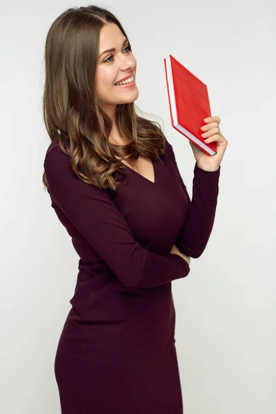 赤い本を持って暗いドレスを着て魅力的な笑顔の若い女性 — ストック写真