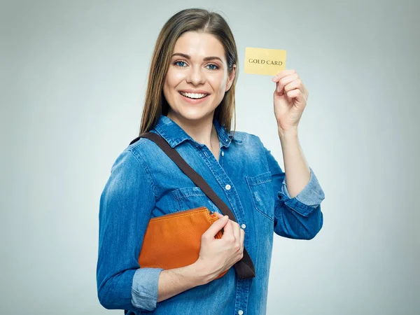 Příležitostné usmívající se žena, oblečená ukazuje zlatá kreditní karta. — Stock fotografie