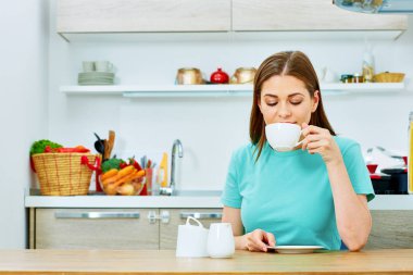 rahat giyimli kadın içme kahve mutfak ev gülümseyen