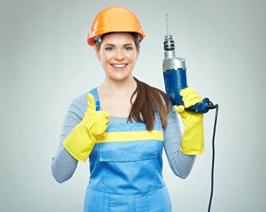 Matkap aracı ve gösteren başparmak dayanabiliyor kadın Oluşturucusu giyen turuncu güvenlik kask gülümseyen