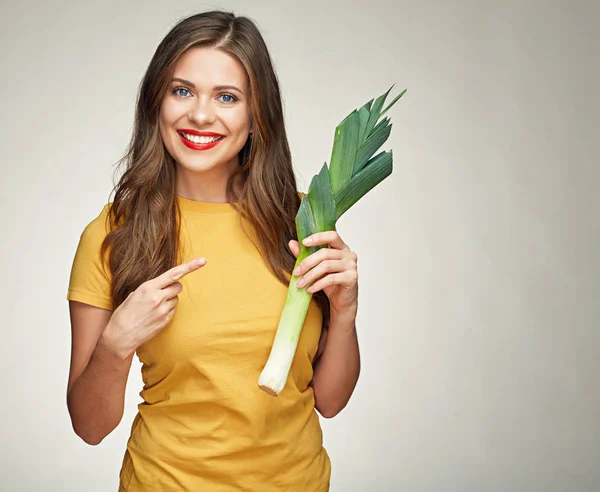 Sorrindo mulher apontando dedo no alho-porro verde . — Fotografia de Stock