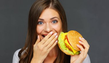 burger holding ve el ile ağız kapsayan bir kadın portresi