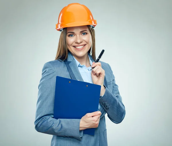 微笑的女实业家建设者穿着橙色安全头盔持有剪贴板与钢笔 — 图库照片