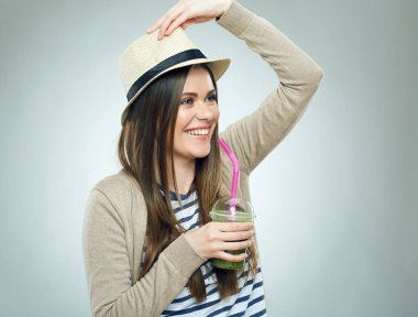 Yeşil yüzlü camla tutan şapkalı gülümseyen kadın 