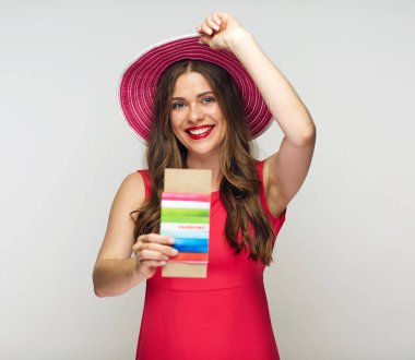 büyük yaz şapka ve şapkasını dokunmaktan ve pasaport ve bilet tutan kırmızı elbise giyen kadın gülümsüyor, seyahat kavramı için hazır  