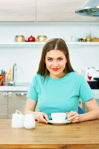 Glimlachend jonge vrouw drinken koffie in keuken. — Stockfoto