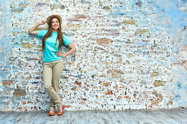 Mujer sonriente posando sobre fondo de pared de ladrillo . — Foto de Stock