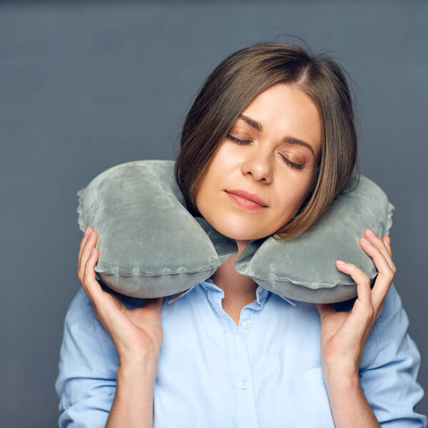 женщина с закрытыми глазами отдыхает с дорожной подушкой
. 