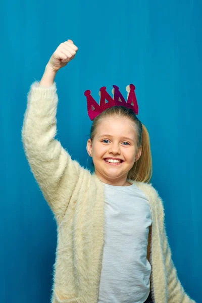 Chica Sonriente Corona Con Mano Levantando Sobre Fondo Pared Azul —  Fotos de Stock