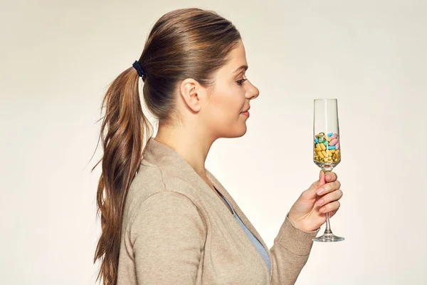 Jonge vrouw met glas met vitaminen pillen — Stockfoto