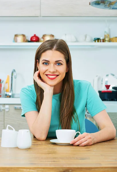 笑顔の美しいカジュアルな服を着た女性が自宅の台所でコーヒーを飲む — ストック写真