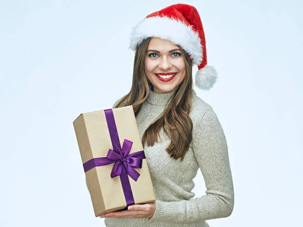 クリスマス プレゼントを持って女性着てサンタの帽子の笑みを浮かべてください — ストック写真