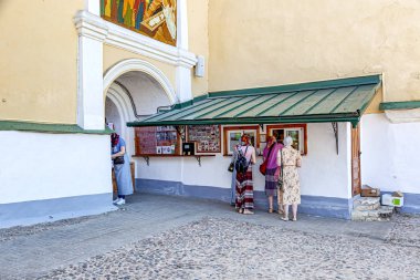 Cemaat üyeleri mum satın alır. Kutsal Dormition Pskovo-Pechersky Manastırı (Pskov-Mağara Manastırı). Tapınak kompleksi