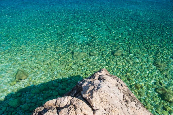 Mar azul-turquesa transparente claro com rocha — Fotografia de Stock