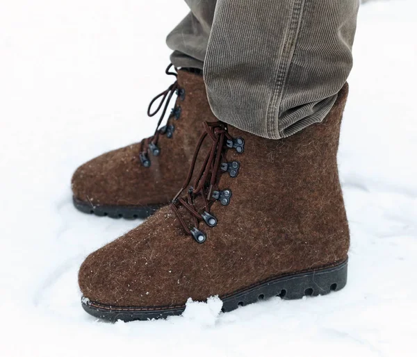 Pés masculinos nos sapatos de lã (Valenki) em fundo de neve — Fotografia de Stock