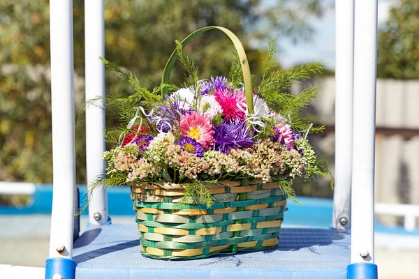 Aster bouquet in a green basket near the pool — Stock Photo, Image