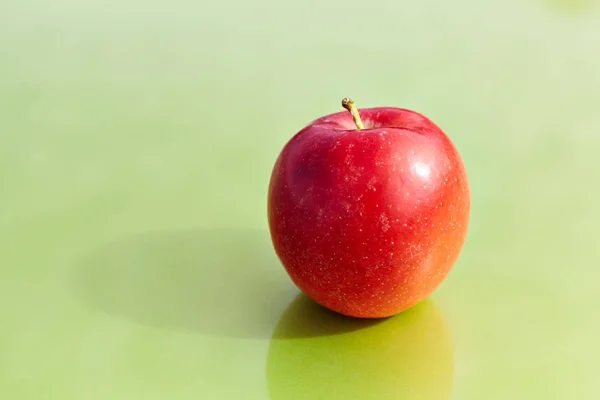 Rött äpple på en grön bakgrund — Stockfoto