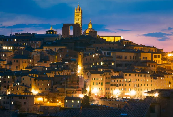 Medieval Siena centro histórico contra las nubes del cielo puesta del sol. Toscana, Italia . — Foto de Stock