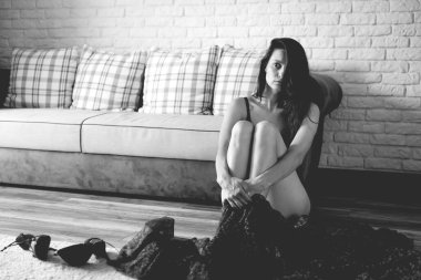 Makyajsız bir kadın kanepede oturuyor ve ruh hali hakkında kendini eleştiriyor. Olumsuz düşüncelerle dolu depresif bir atış..