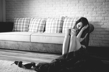 Makyajsız bir kadın kanepede oturuyor ve ruh hali hakkında kendini eleştiriyor. Olumsuz düşüncelerle dolu depresif bir atış..