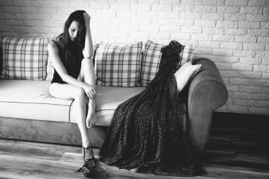 Makyajsız bir kadın kanepede oturuyor ve ruh hali hakkında kendini eleştiriyor. Olumsuz düşüncelerle dolu depresif bir atış..