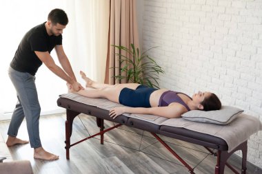 Evde bir fizyoterapist tarafından masaj sezyonu geçirilen genç bir kadın..