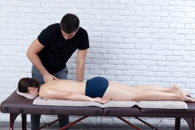 Evde bir fizyoterapist tarafından masaj sezyonu geçirilen genç bir kadın..