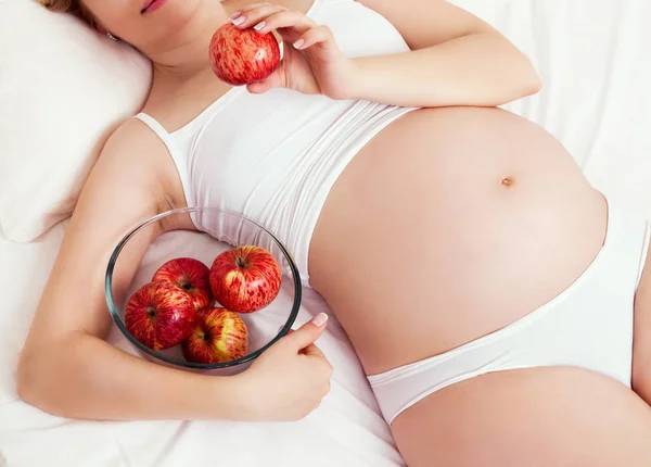 Femme enceinte avec des pommes — Photo