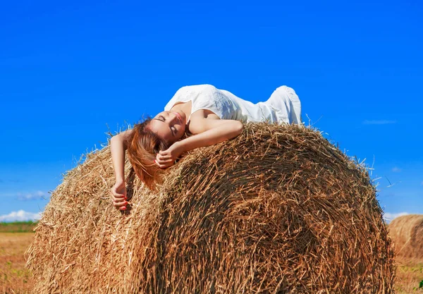 Bela mulher no campo de trigo colhido — Fotografia de Stock