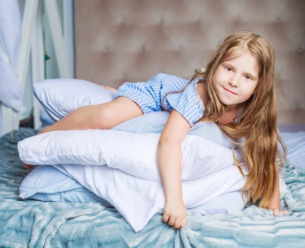 Ragazza con un cuscino a letto — Foto Stock