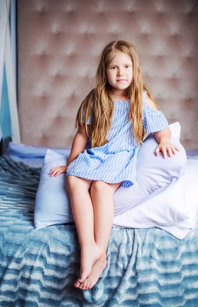 Menina com um travesseiro na cama — Fotografia de Stock