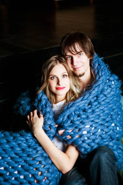 Heureux beau jeune couple avec une couverture — Photo