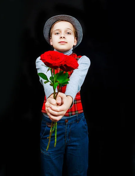 Hansome menino com rosas em suas mãos — Fotografia de Stock