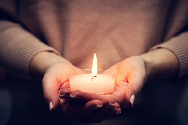 Candle glowing in woman hands — Stock Photo, Image