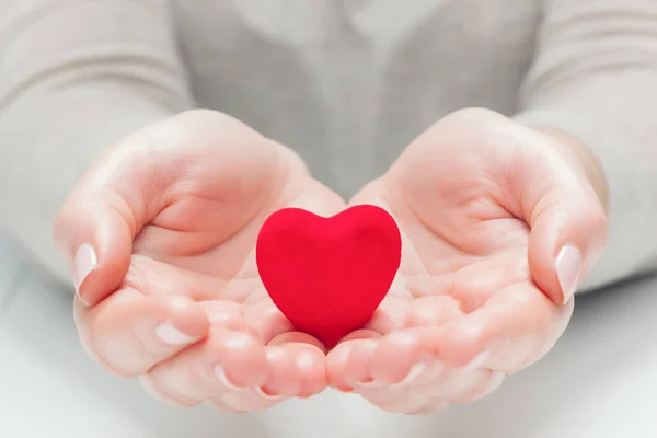 Litet rött hjärta i kvinna händer — Stockfoto