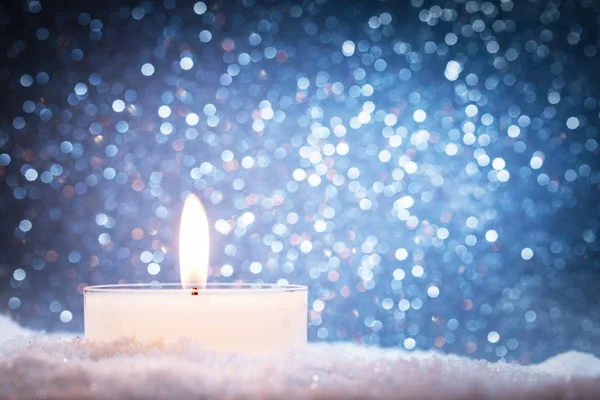 Burning candle on snow — Stock Photo, Image