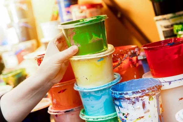 Artist reaching for a liquid paint container. — Stock Photo, Image