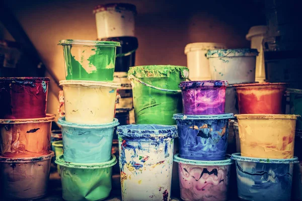 Des seaux de peinture liquide debout dans un atelier . — Photo