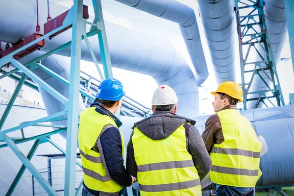 Engenheiros discutindo manutenção de usina petroquímica — Fotografia de Stock