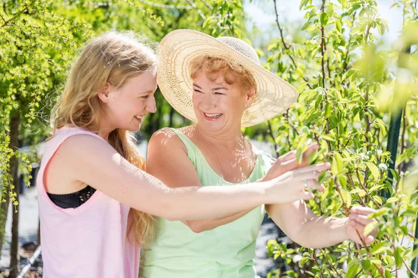 Granddaughter and grandmother spending time in garden — Stock Photo, Image