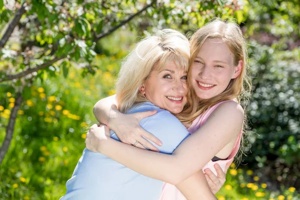 Madre e hija abrazándose en el jardín de verano — Foto de Stock
