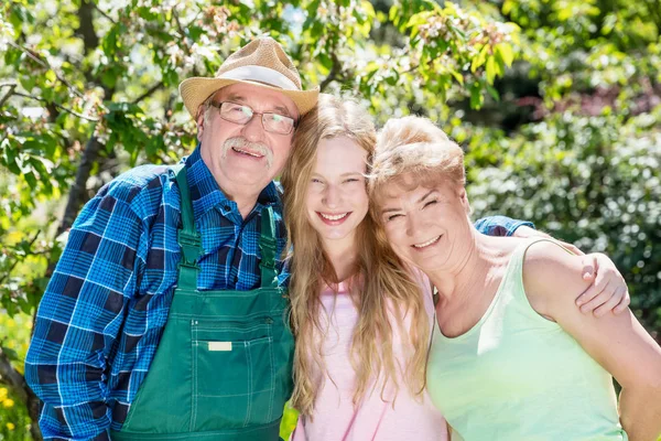 Nipote abbracciare nonni in giardino . — Foto Stock