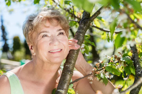 Reife Frau umarmt Baum — Stockfoto