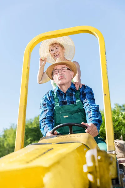 Großvater fährt mit Oma auf Traktor — Stockfoto
