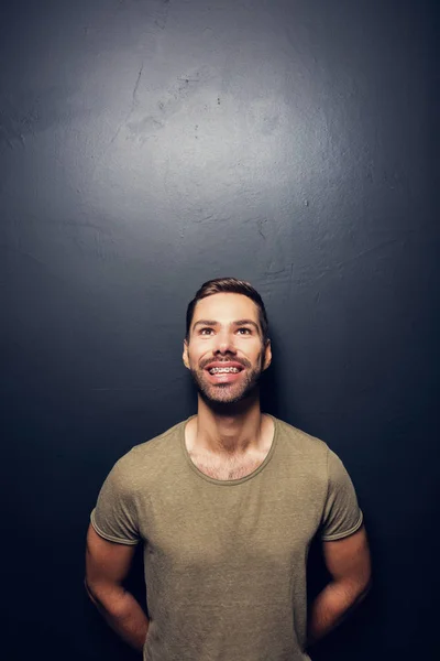 Támaszkodva a falon, mosolygó ember — Stock Fotó