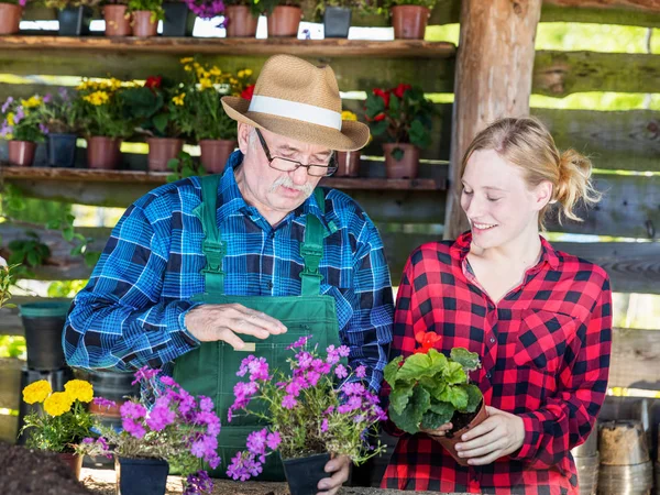 Farfar visar grandaughter hur att plantera blommor. — Stockfoto